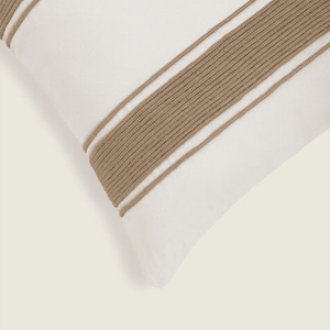 Capa de almofada decorativa no tamanho 50x50 cm na cor branca confeccionada em algodão sustentável com bordados rústicos de juta natural com fechamento em zíper invisível, ideal para complementar jogos de cama ou sofás, aliando conforto ergonômico e design moderno.
