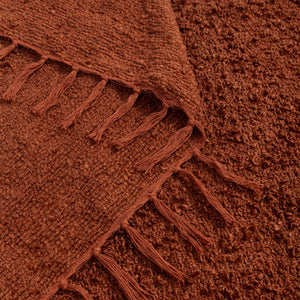 Manta decorativa para sofá e cama no tamanho 130X170 cm na cor terracota confeccionada em tecido de toque macio e confortável com acabamento refinado, ideal para aquecer os dias mais frios enquanto renova a estética do ambiente com sofisticação.