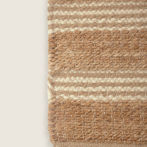 Tapete de algodão decorativo na cor natural confeccionado em tecido tramado com toque macio com costuras e acabamentos reforçados nas bordas, ideal para complementar salas, quartos ou closets com um toque de design têxtil autêntico.